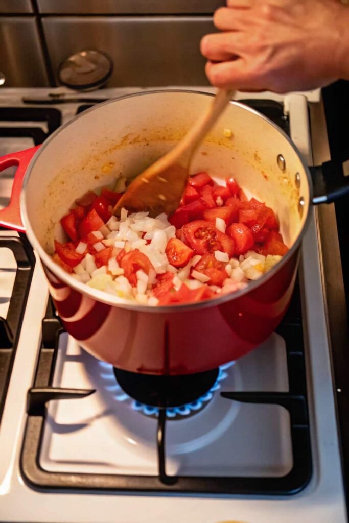adding tomatoes to the pot